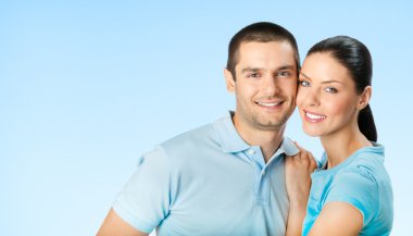 Neşeli genç çift, mavi gökyüzü gülümseyen
