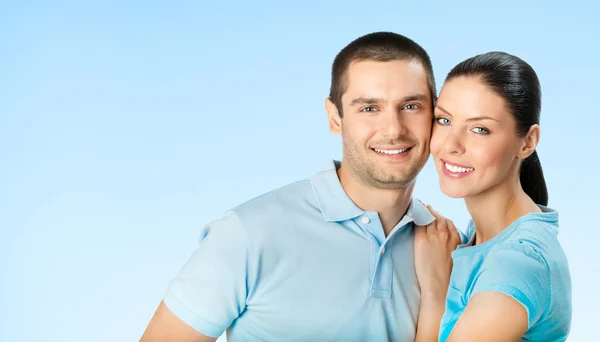 Glada leende unga par, på blå himmel — Stockfoto