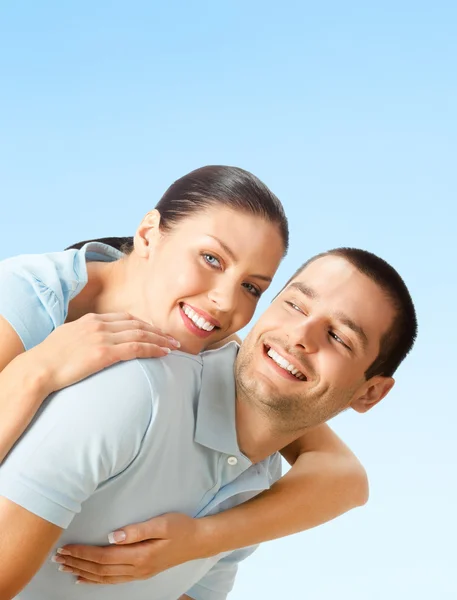 Happy smiling young couple, over blue Stock Picture