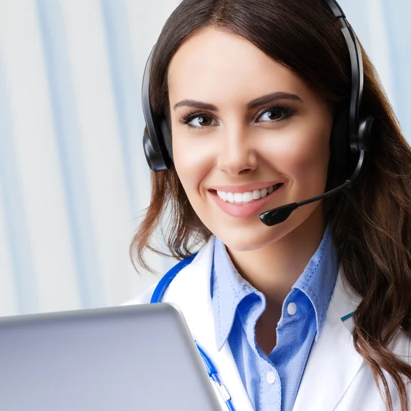 Jeune médecin dans casque et ordinateur portable — Photo