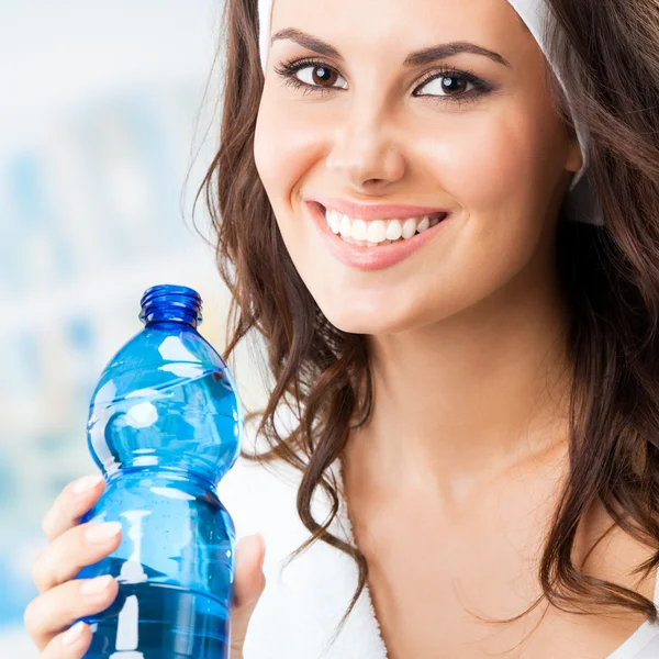 Portrait of smiling young woman with bottle of water — Stock Photo, Image