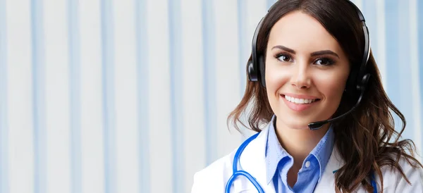 Smiling young doctor in headset, at office — Stock Photo, Image