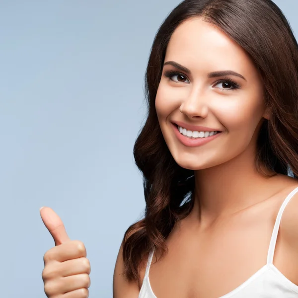 Portret van vrouw duim omhoog gebaar, waarop grijs — Stockfoto