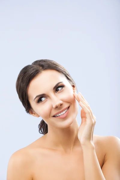 Woman touching skin or applying cream, on grey — Stock Photo, Image