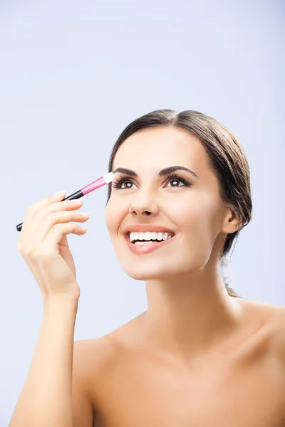 Mujer con cepillo de cosméticos, sobre gris —  Fotos de Stock