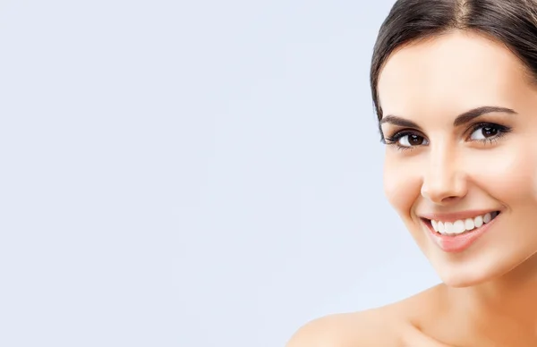 Retrato de bela mulher sorridente, em cinza — Fotografia de Stock