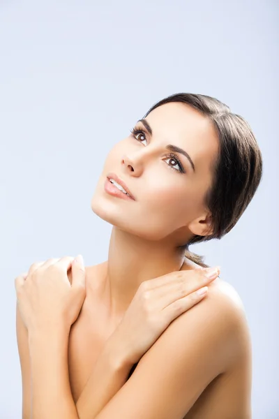 Woman with crossed arms, looking up, over grey — Stock Photo, Image