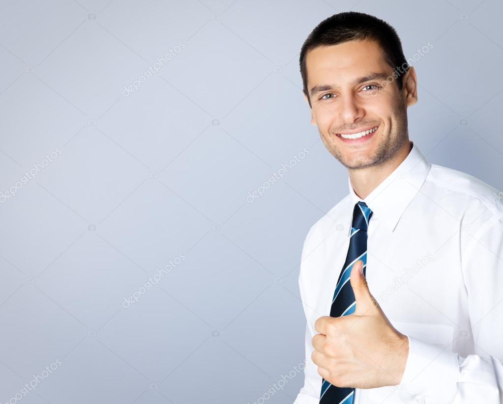 Smiling businessman with thumbs up gesture, with copyspace