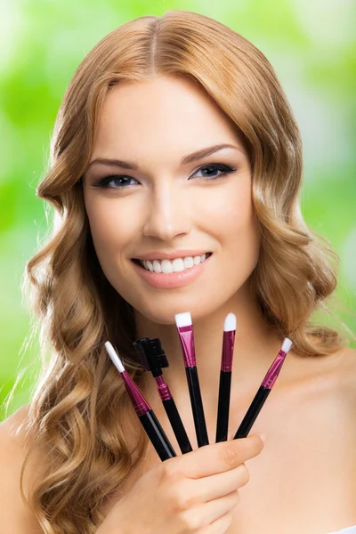 Gelukkig vrolijke lachende blonde vrouw met make-up tools, buiten — Stockfoto