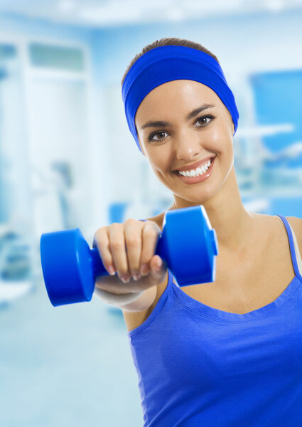 woman in sportswear doing fitness exercises with dumbbell