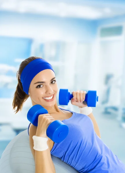 Mujer en ropa deportiva haciendo ejercicio con bolas de pilates y mancuernas , — Foto de Stock