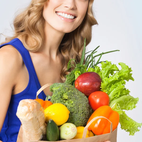 Donna sorridente con cibo vegetariano, su blu — Foto Stock