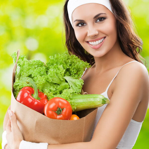 smiling woman in fitness wear with vegetarian food