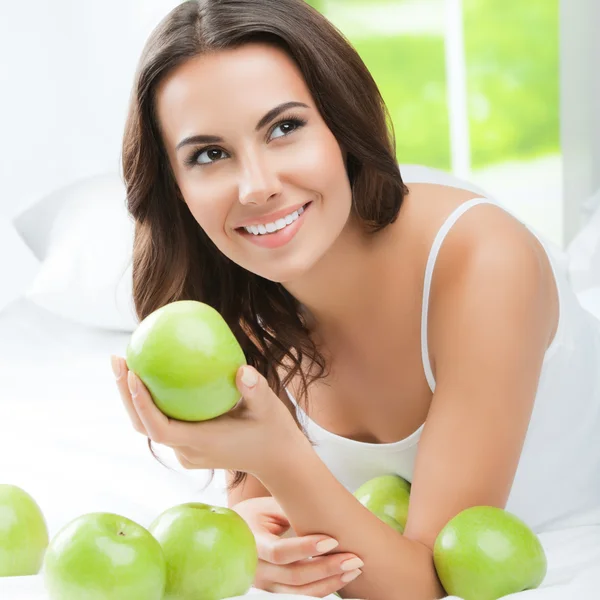 Felice donna sorridente con mele verdi, in casa — Foto Stock