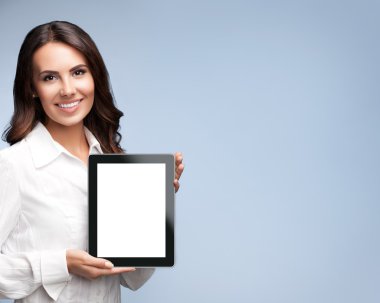 Businesswoman showing blank tablet pc, on grey, with copyspace