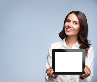 Businesswoman showing blank tablet pc, on grey, with copyspace