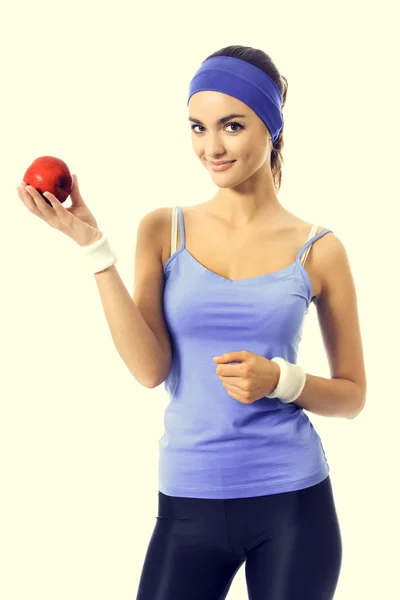 Portrait of woman in violet sportswear with apple — Stock Photo, Image