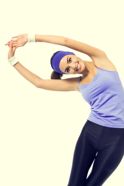 Smiling woman, in violet sportswear, doing stretching exercise o — Stock Photo, Image