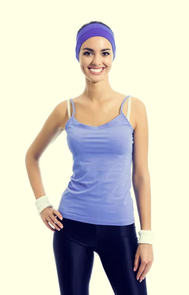 Усміхнена спортивна брюнетка у фіолетовому спортивному одязі — стокове фото