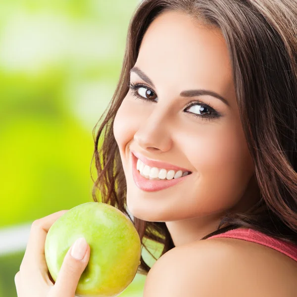 Jeune belle femme avec pomme verte, à l'extérieur — Photo