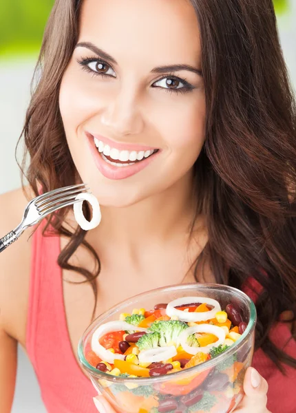 Улыбающаяся женщина с салатом, на открытом воздухе — стоковое фото
