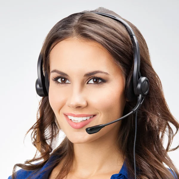 Sonriente joven operador de telefonía de apoyo femenino, con copyspace, en — Foto de Stock