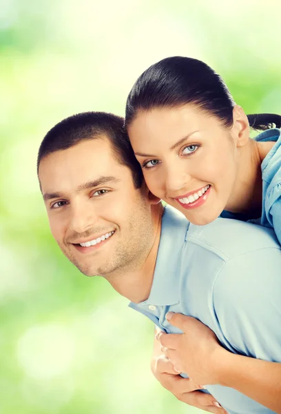 Jovem feliz amoroso abraçando lindo casal, ao ar livre — Fotografia de Stock