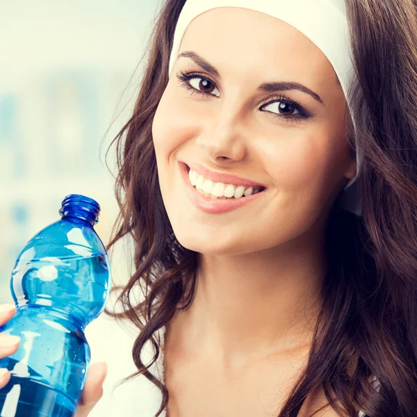 Mujer con botella de agua, en el gimnasio — Foto de Stock