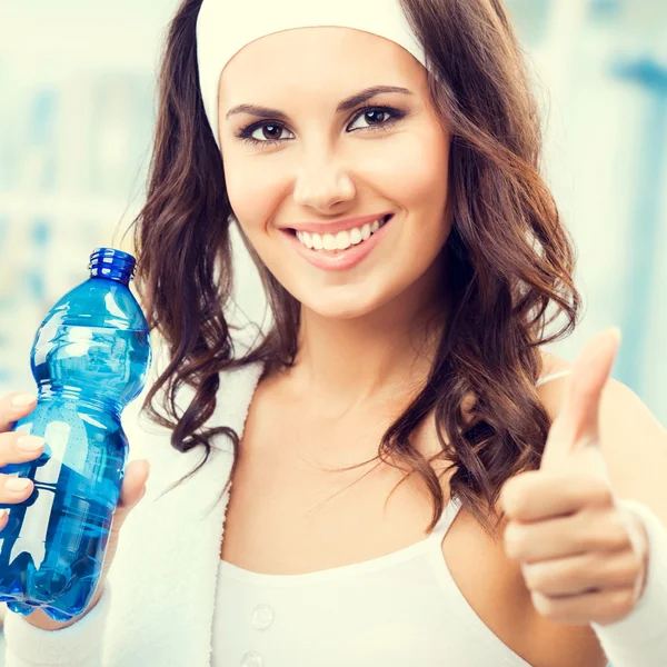 Mujer feliz con botella de agua, en el gimnasio —  Fotos de Stock