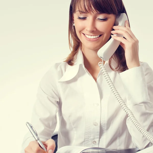 Businesswoman with phone writing — Stockfoto