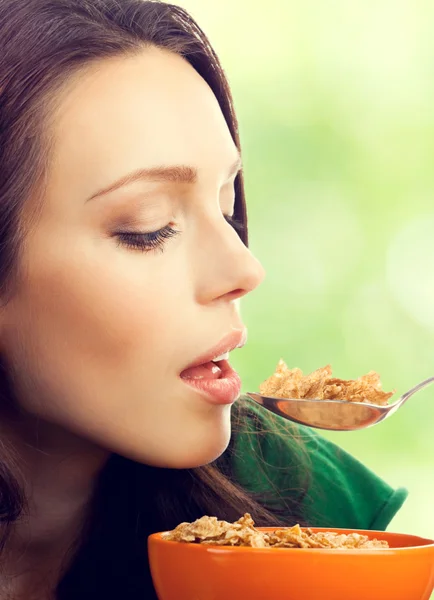 Mulher morena comendo muesli ou flocos de milho — Fotografia de Stock