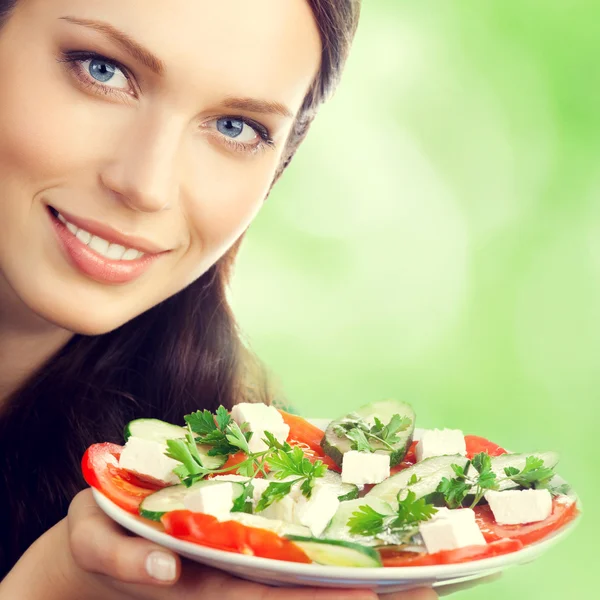 Young brunette woman with plate of salad Royalty Free Stock Images