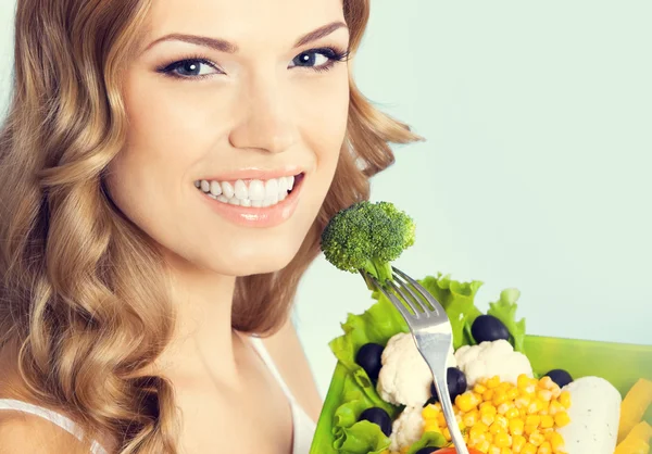 Linda mulher com salada vegetariana, sobre azul — Fotografia de Stock