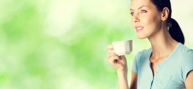 smiling lovely brunette woman drinking coffee, outdoor