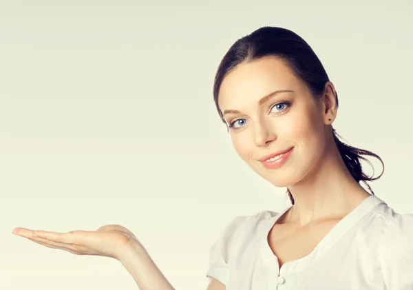 Joven mujer de negocios mostrando algo o copia en blanco — Foto de Stock