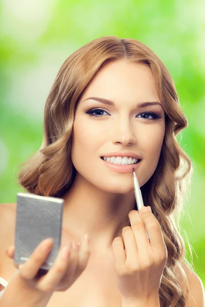 Happy smiling lovely woman with make up brush and mirror, outdoo — Stockfoto