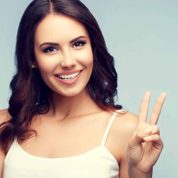 Mujer sonriente mostrando dos dedos o gesto de victoria — Foto de Stock