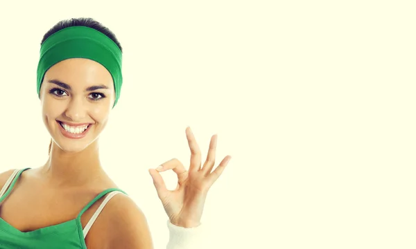 Mulher alegre em desgaste fitness verde com sinal ok com copyspa — Fotografia de Stock