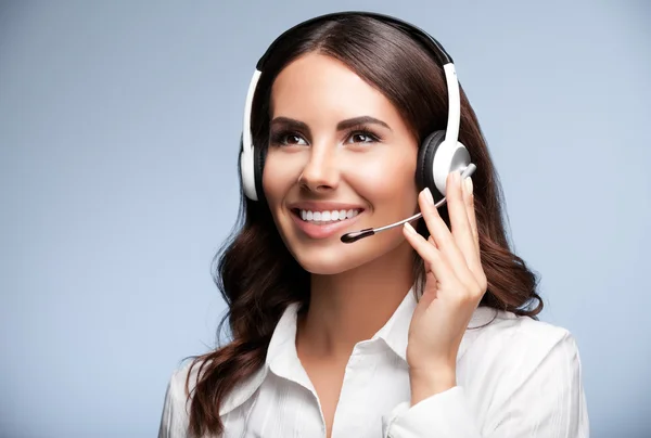 Klant ondersteuning vrouwelijke telefoon worker, opzoeken, tegen grijs — Stockfoto