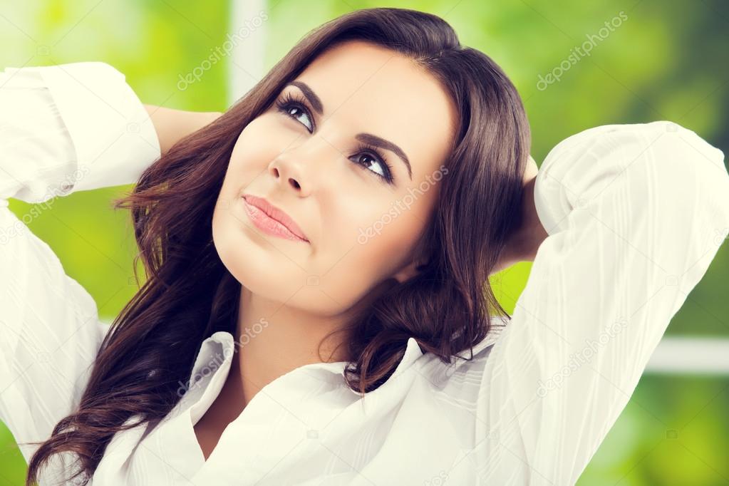 thinking brunette businesswoman looking up, at office