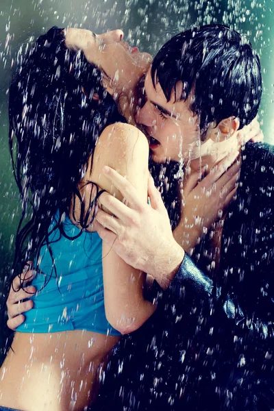 Young couple hugging and kissing under a rain — Stock Photo, Image