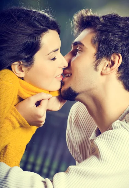 Mladý atraktivní šťastný zamilovaný pár líbání venku — Stock fotografie