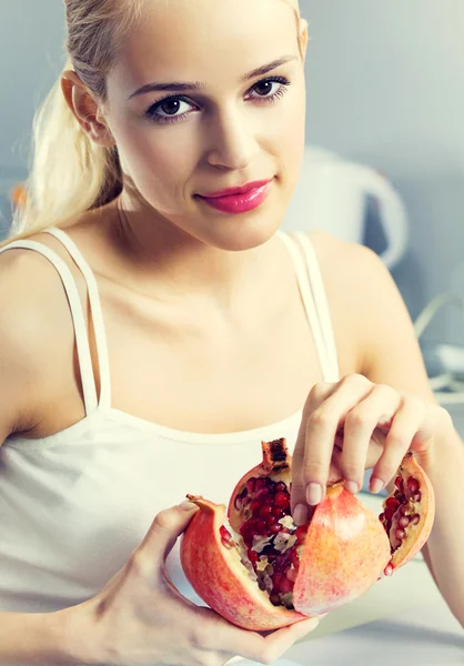 Vrouw met granaatappel binnenshuis — Stockfoto