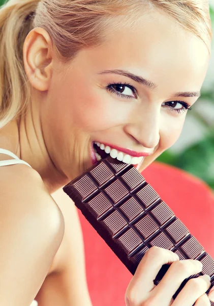 Счастливая женщина ест шоколад дома — стоковое фото