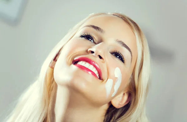 Usmívající se žena použití crème doma — Stock fotografie