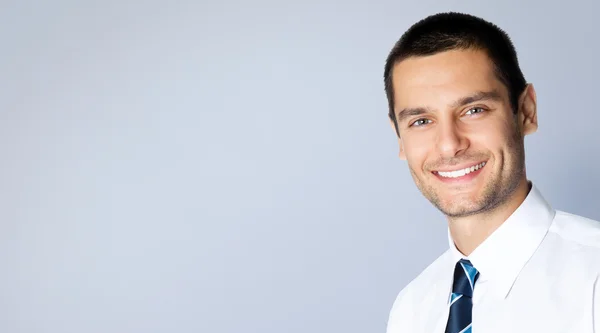 Hombre de negocios sonriente, en gris — Foto de Stock