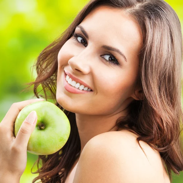 Jonge gelukkig lachende vrouw met apple, buitenshuis — Stockfoto