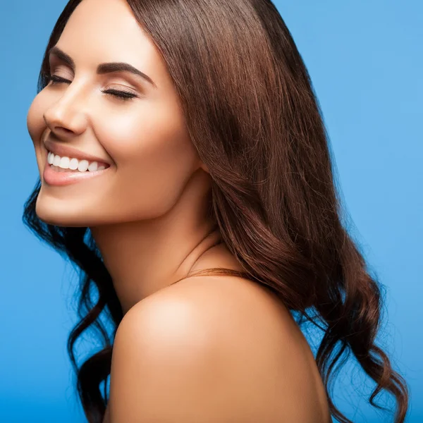 Smiling young woman with closed eyes, on blue — Stock Photo, Image