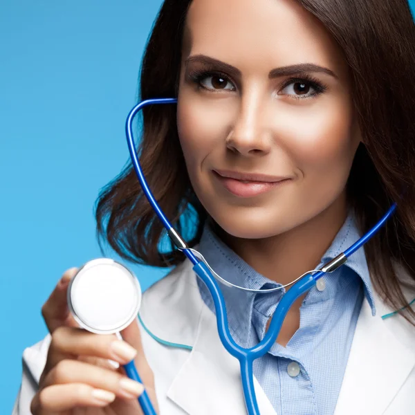 Medico con stetoscopio in mano, su blu — Foto Stock