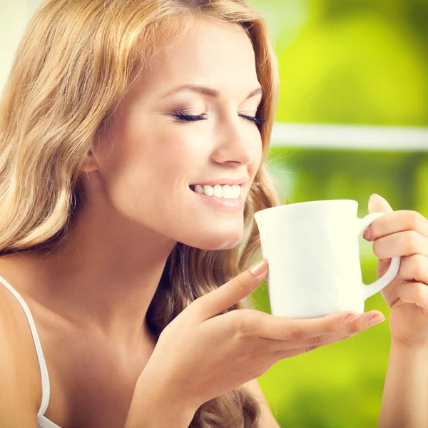 Mujer joven bebiendo café o té, en casa — Foto de Stock